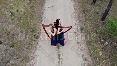 从无人驾驶到两个女<strong>竖琴</strong>手站在森林道路上<strong>演奏竖琴</strong>。